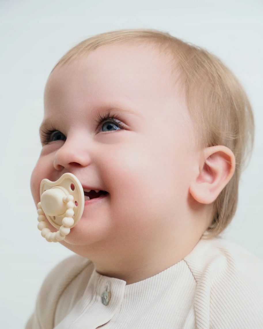 LUU KIDS SMOCZEK SILIKONOWY POZYCJONUJACY 0-3 AMERICAN CREAM